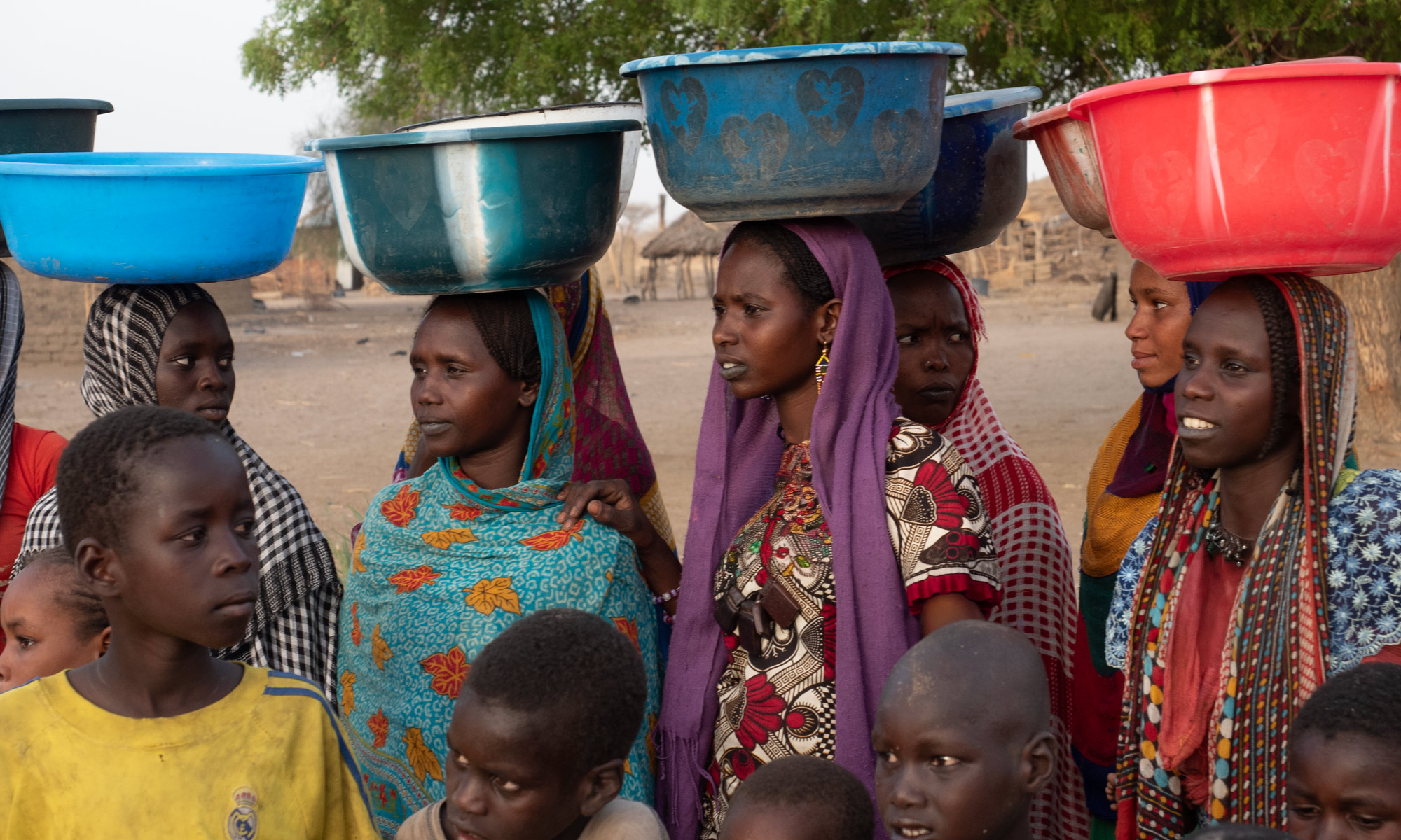 Kafasıdaki kovalarla su doldurlama giden Afrika'lı kadınlar